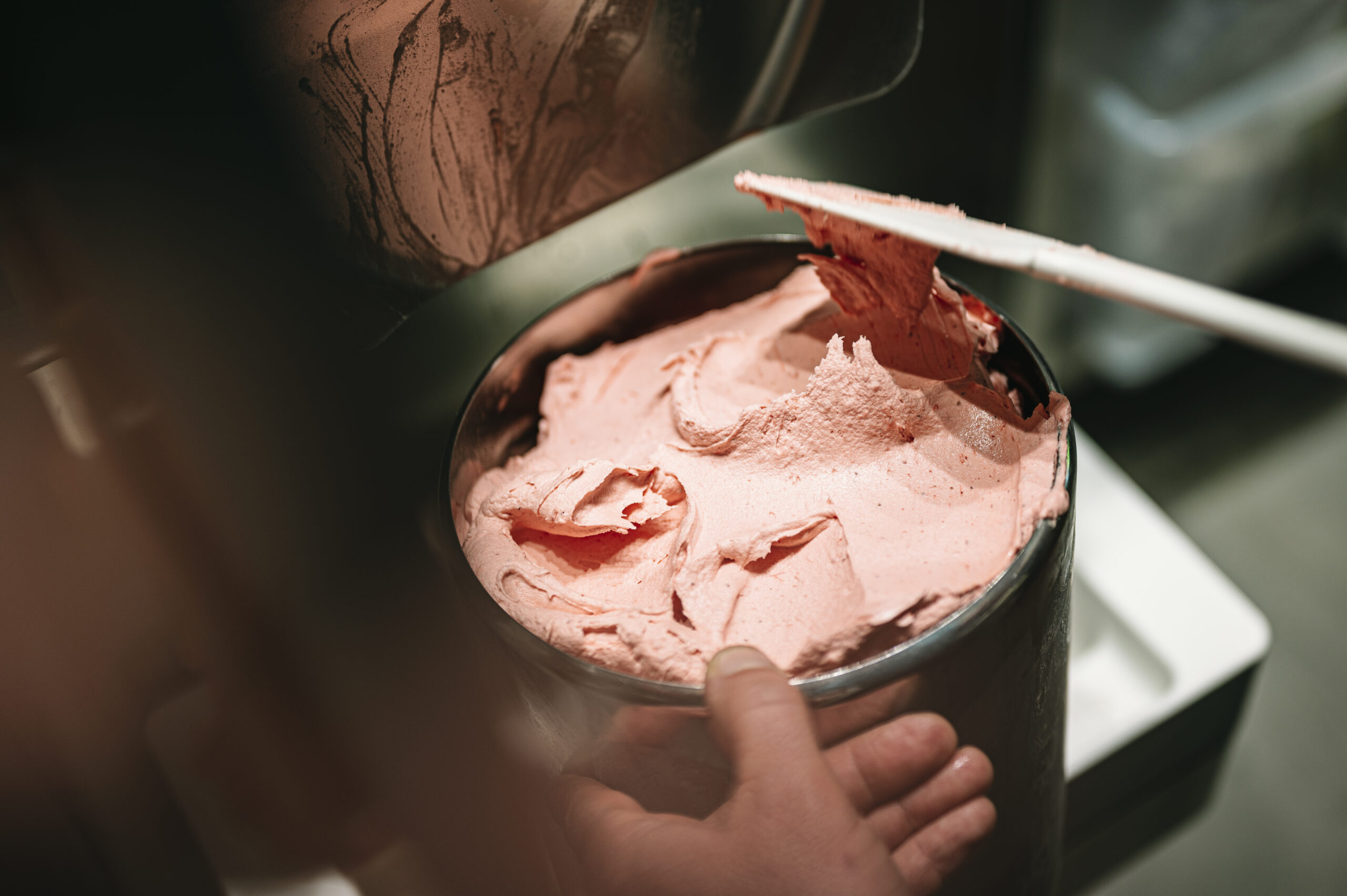 Frisch hergestelltes Fruchtgelato wird bei einem Eisworkshop in einen Metallbehälter gefüllt